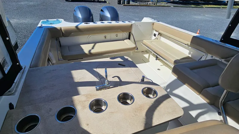 Slide: The Image of 2019 Sailfish 275 DC boat interior with seating, table, and cup holders. - 16