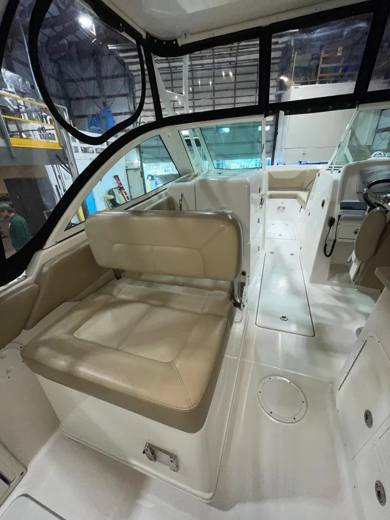 Slide: The Image of 2019 Sailfish 275 DC boat interior with beige seating and modern dashboard. - 19
