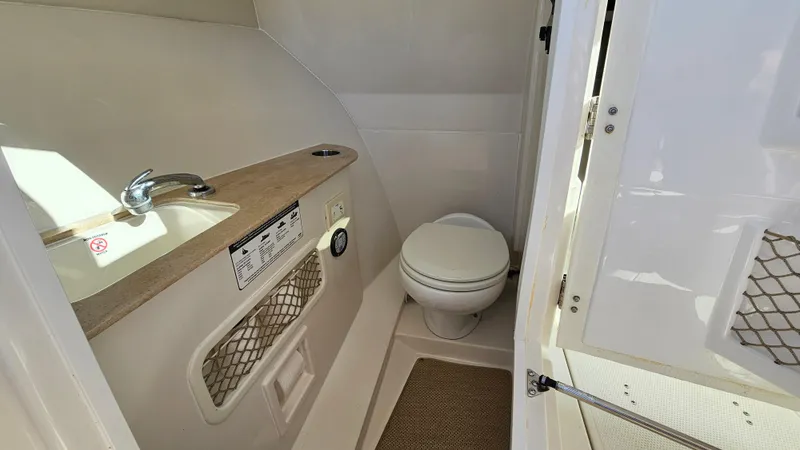 Slide: The Image of 2019 Sailfish 275 DC boat interior bathroom with sink and toilet. - 29