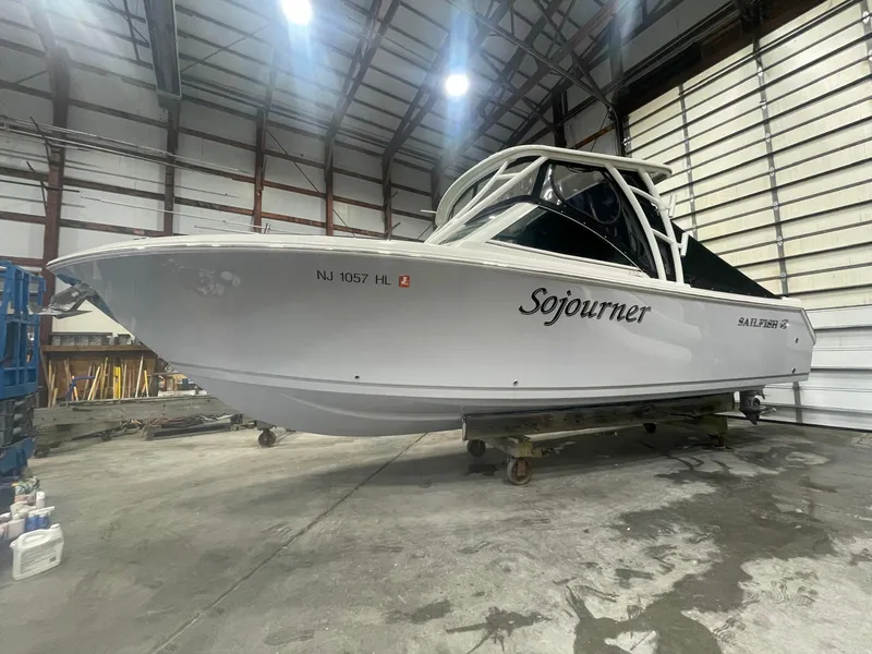 Slide: The Image of 2019 Sailfish 275 DC boat named "Sojourner" in a warehouse setting. - 40
