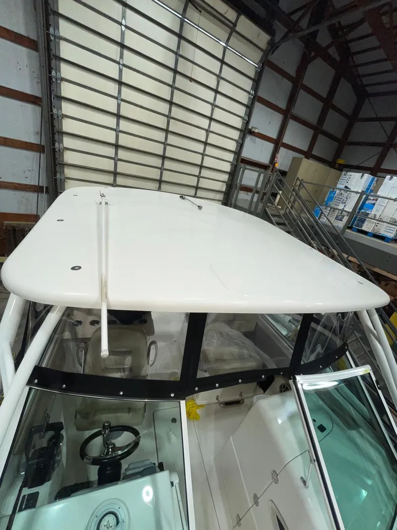 Slide: The Image of 2019 Sailfish 275 DC boat in storage, showcasing helm and hardtop. - 41