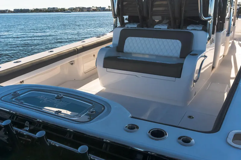 Slide: The Image of 2026 Mag Bay 43 CC boat interior with seating and rod holders, overlooking calm waters. - 14