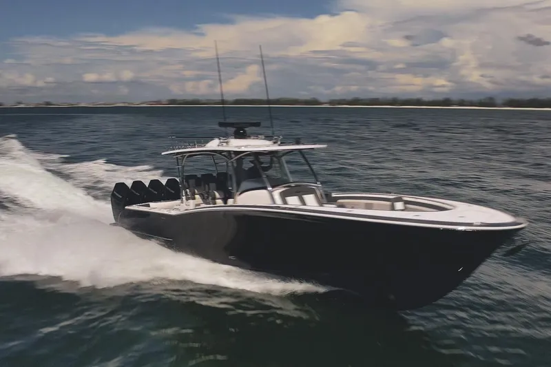 Slide: The Image of 2026 Mag Bay 43 CC boat cruising on open water under a cloudy sky. - 31