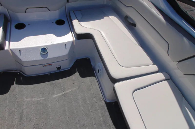 Slide: The Image of 2023 Yamaha Boats AR190 interior seating with cup holders and carpeted flooring. - 14