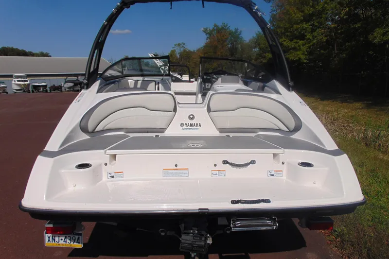Slide: The Image of 2023 Yamaha Boats AR190, rear view, white and gray design, parked outdoors. - 4