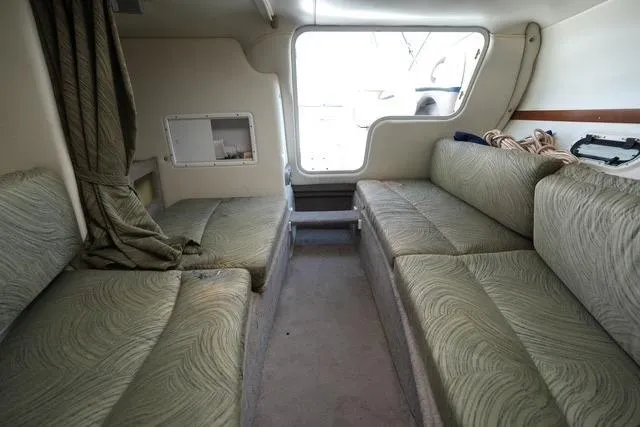 Slide: The Image of Interior cabin of 2004 Four Winns 245 Sundowner with green seating and window view. - 10