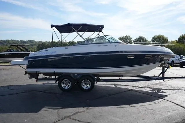 Slide: The Image of 2004 Four Winns 245 Sundowner boat on trailer, parked outdoors under clear sky. - 3