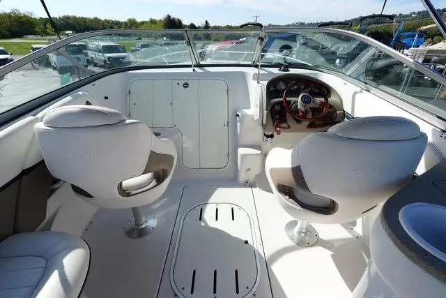 Slide: The Image of 2004 Four Winns 245 Sundowner boat interior with dual swivel seats and steering console. - 8