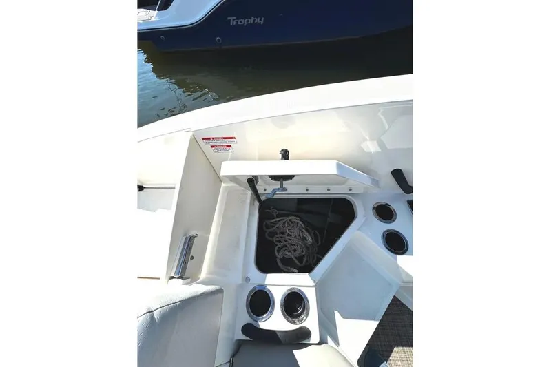 Slide: The Image of 2021 Sea Ray SPX 210 Outboard boat interior with storage compartment and cup holders. - 21