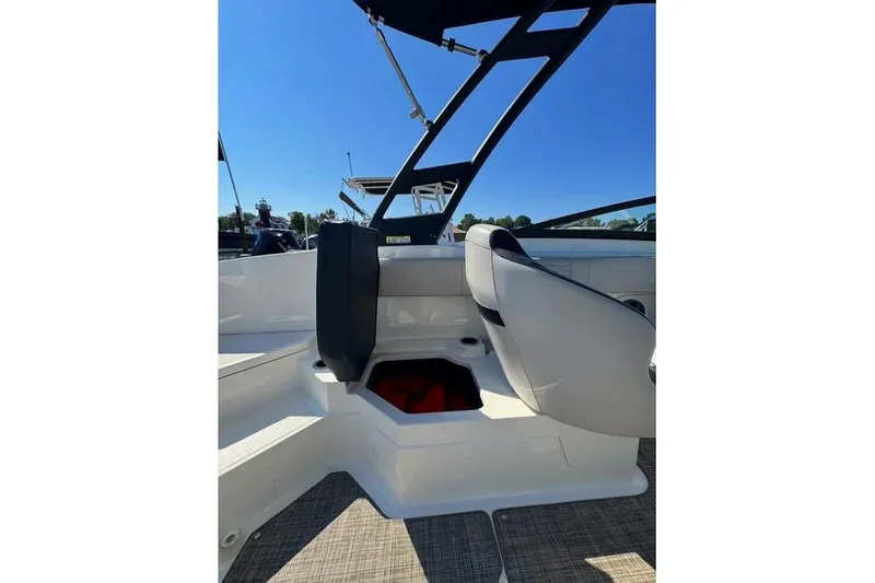 Slide: The Image of 2021 Sea Ray SPX 210 Outboard interior with seating and storage, under clear blue sky. - 22