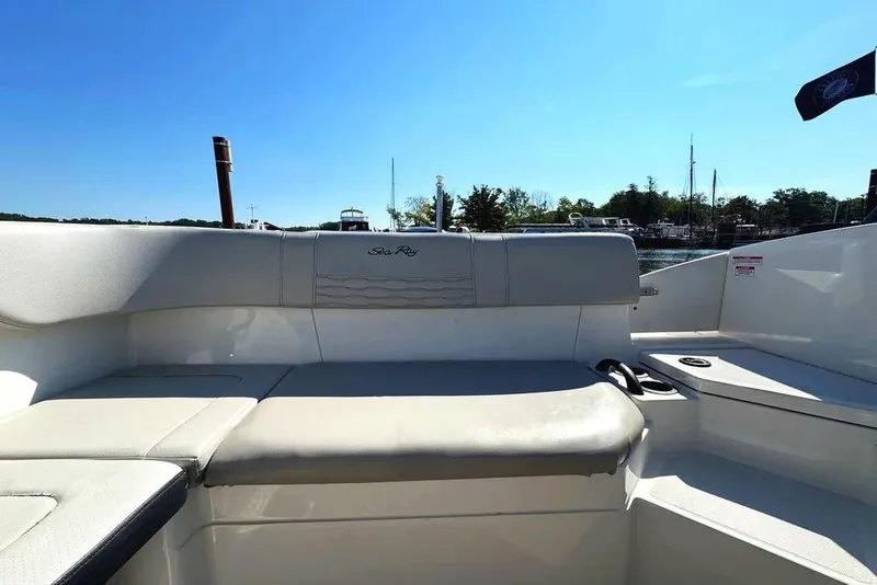 Slide: The Image of 2021 Sea Ray SPX 210 Outboard boat interior with comfortable seating and scenic marina view. - 23