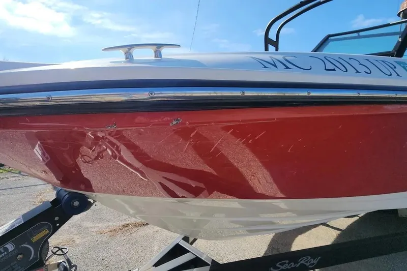 Slide: The Image of 2021 Sea Ray SPX 210 Outboard boat with red hull and visible scratches. - 29