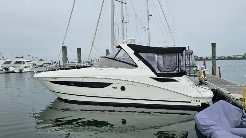 Slide: The Image of 2014 Sea Ray 350 Sundancer yacht docked at marina, featuring sleek design and black canopy. - 1