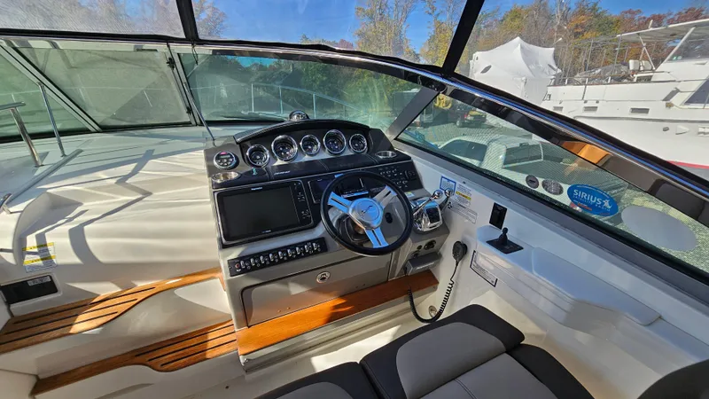 Slide: The Image of 2014 Sea Ray 350 Sundancer helm with modern controls and navigation system. - 13