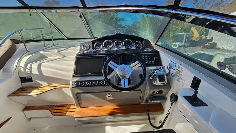 Slide: The Image of 2014 Sea Ray 350 Sundancer helm with modern controls and wooden accents. - 14
