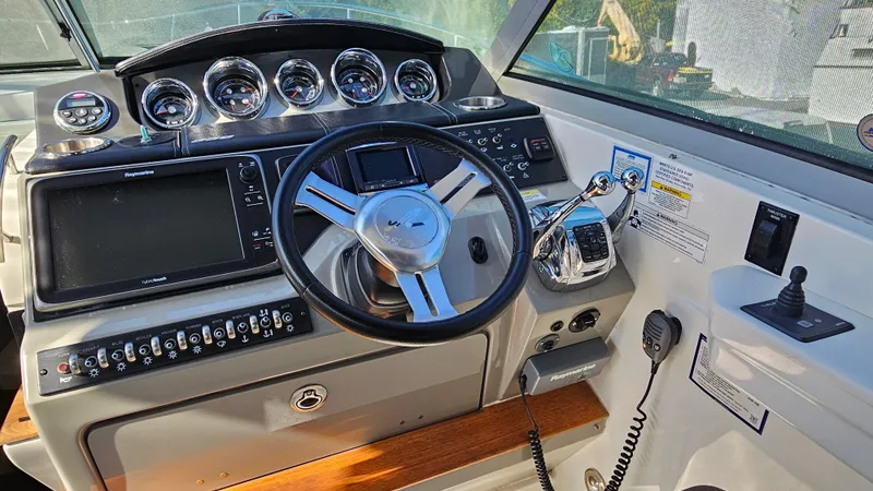 Slide: The Image of Control panel of 2014 Sea Ray 350 Sundancer boat with steering wheel and gauges. - 16