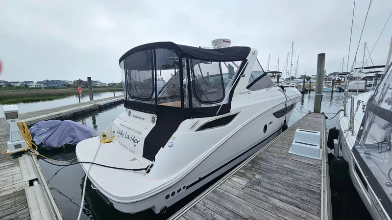 Slide: The Image of 2014 Sea Ray 350 Sundancer yacht docked at marina, featuring sleek design and covered cockpit. - 2