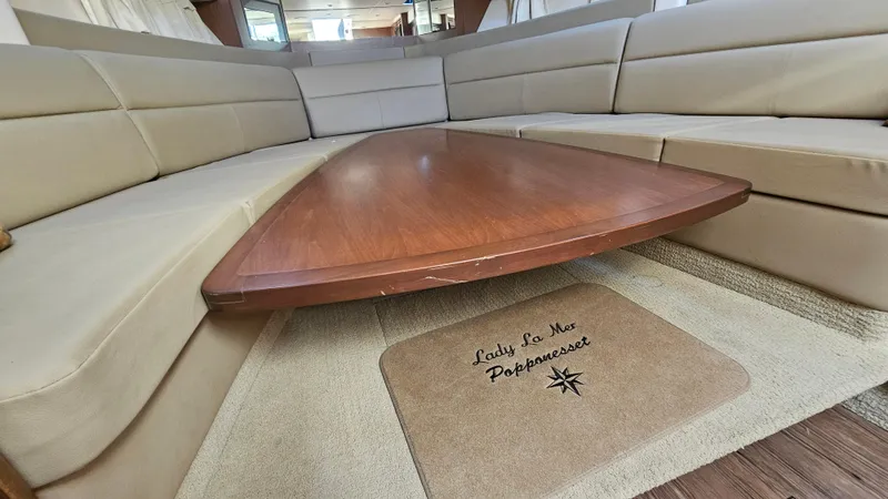 Slide: The Image of Interior of 2014 Sea Ray 350 Sundancer with beige seating and wooden table. - 20