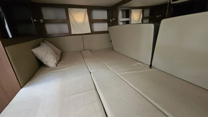 Slide: The Image of Interior cabin of 2014 Sea Ray 350 Sundancer with beige cushions and pillows. - 22