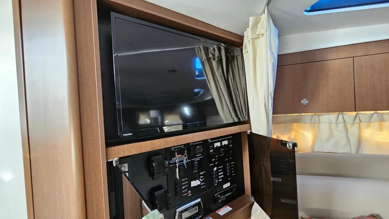 Slide: The Image of Interior of 2014 Sea Ray 350 Sundancer with mounted TV and control panel. - 24