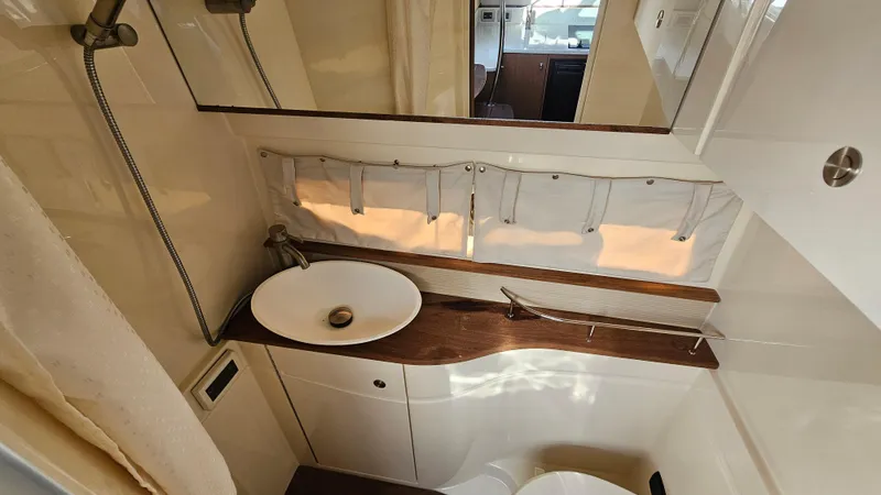 Slide: The Image of 2014 Sea Ray 350 Sundancer bathroom with modern sink and wooden countertop. - 26