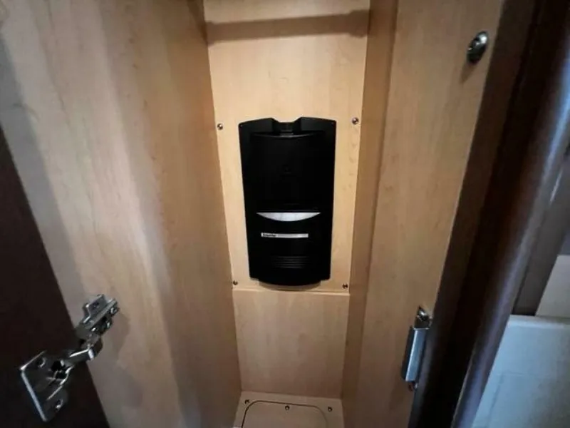 Slide: The Image of 2014 Sea Ray 350 Sundancer interior cabinet with mounted black device. - 27