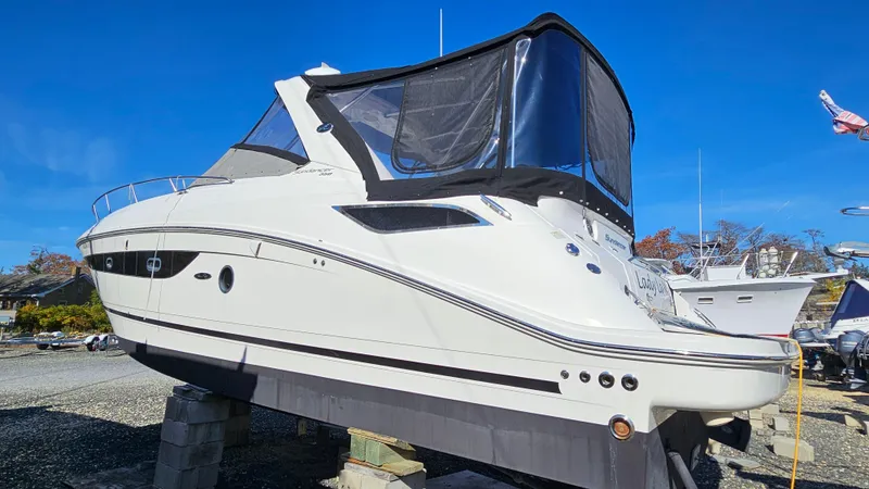 Slide: The Image of 2014 Sea Ray 350 Sundancer boat on dry dock, side view, clear blue sky. - 32