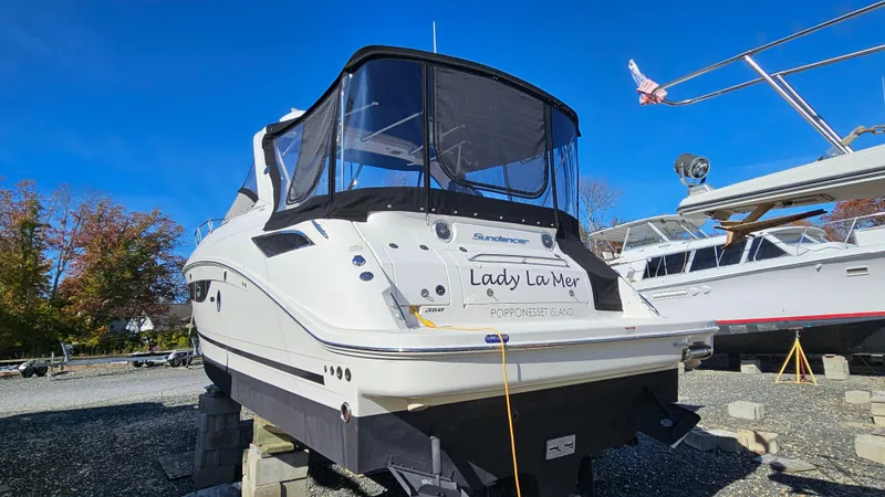 Slide: The Image of 2014 Sea Ray 350 Sundancer boat on blocks, outdoor storage, clear blue sky. - 33