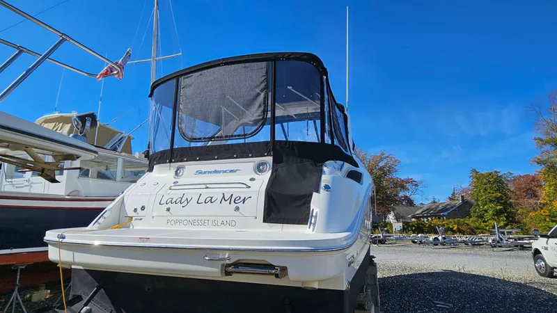 Slide: The Image of 2014 Sea Ray 350 Sundancer boat docked, featuring a black canopy and clear blue sky. - 34