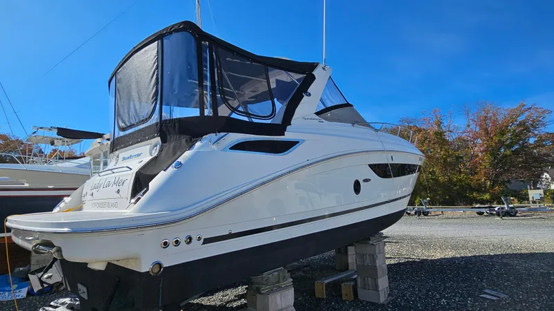 Slide: The Image of 2014 Sea Ray 350 Sundancer boat on blocks, clear sky background. - 35