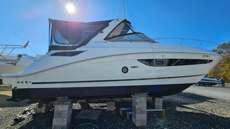 Slide: The Image of 2014 Sea Ray 350 Sundancer boat on blocks under clear blue sky. - 36
