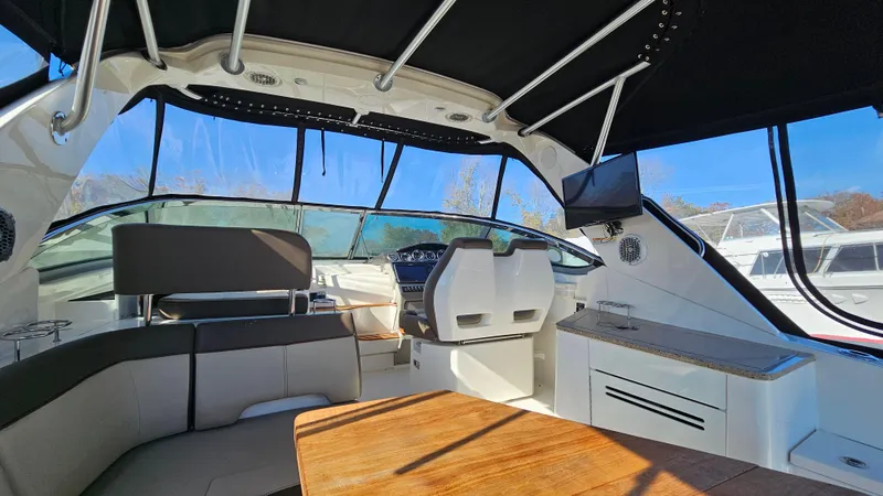 Slide: The Image of Interior of 2014 Sea Ray 350 Sundancer yacht with seating, helm, and TV. - 4