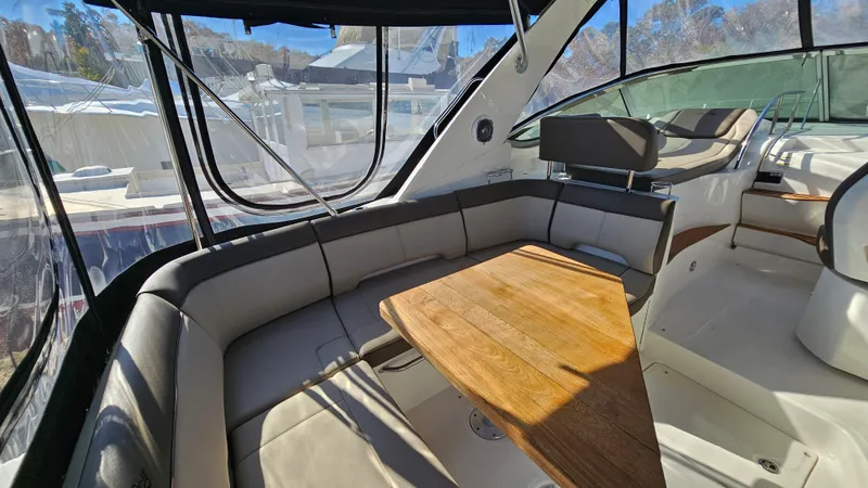 Slide: The Image of 2014 Sea Ray 350 Sundancer interior with seating and wooden table. - 5