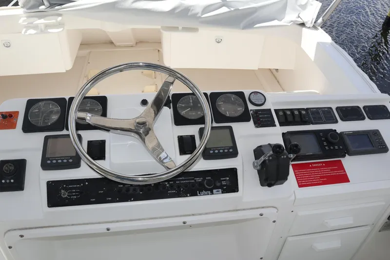 Slide: The Image of Control panel of a 2005 Luhrs 38 Convertible boat with steering wheel and navigation instruments. - 12