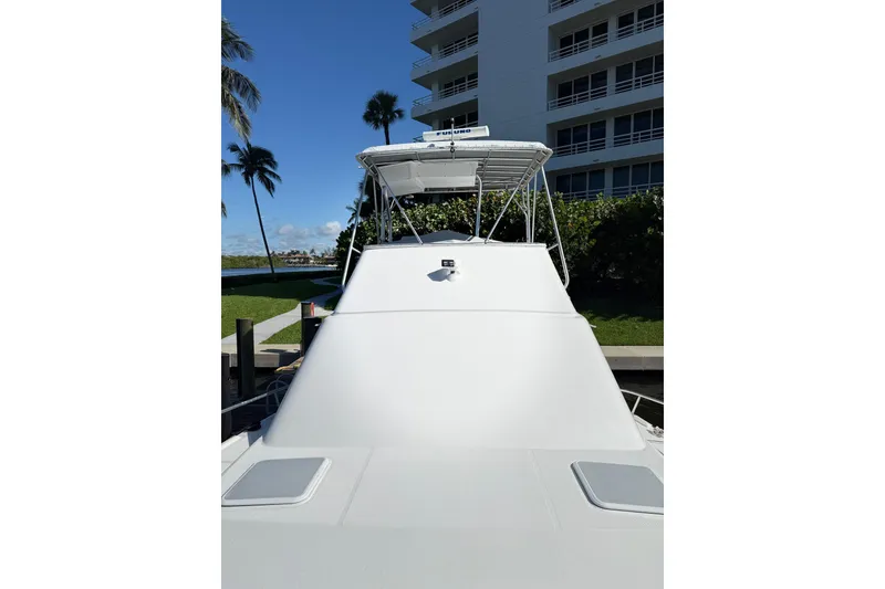 Slide: The Image of 2005 Luhrs 38 Convertible yacht docked near a waterfront building. - 18