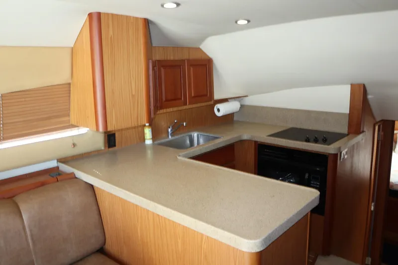 Slide: The Image of 2005 Luhrs 38 Convertible yacht kitchen with wood cabinetry and modern appliances. - 23