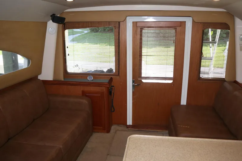 Slide: The Image of Interior of 2005 Luhrs 38 Convertible yacht with brown seating and wooden door. - 34