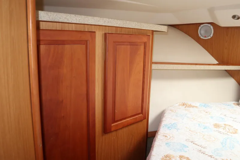 Slide: The Image of 2005 Luhrs 38 Convertible cabin interior with wood cabinetry and patterned bedding. - 37