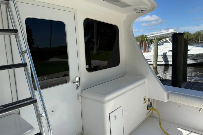 Slide: The Image of 2005 Luhrs 38 Convertible yacht deck with ladder and docked boats in background. - 4