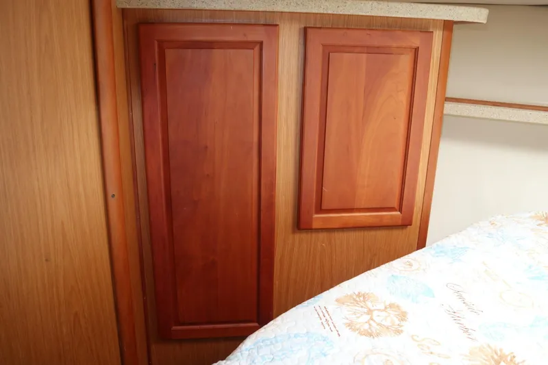 Slide: The Image of Interior of 2005 Luhrs 38 Convertible boat with wooden cabinetry and patterned bedding. - 46