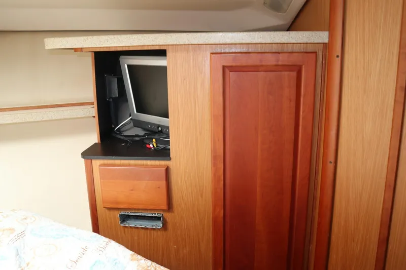 Slide: The Image of 2005 Luhrs 38 Convertible interior with built-in TV and wooden cabinetry. - 47