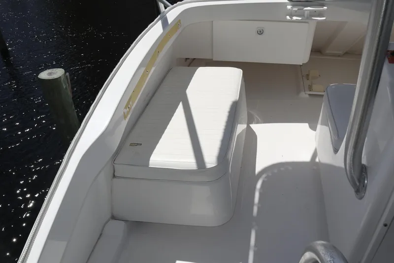 Slide: The Image of 2005 Luhrs 38 Convertible boat deck with white seating and storage compartment. - 65