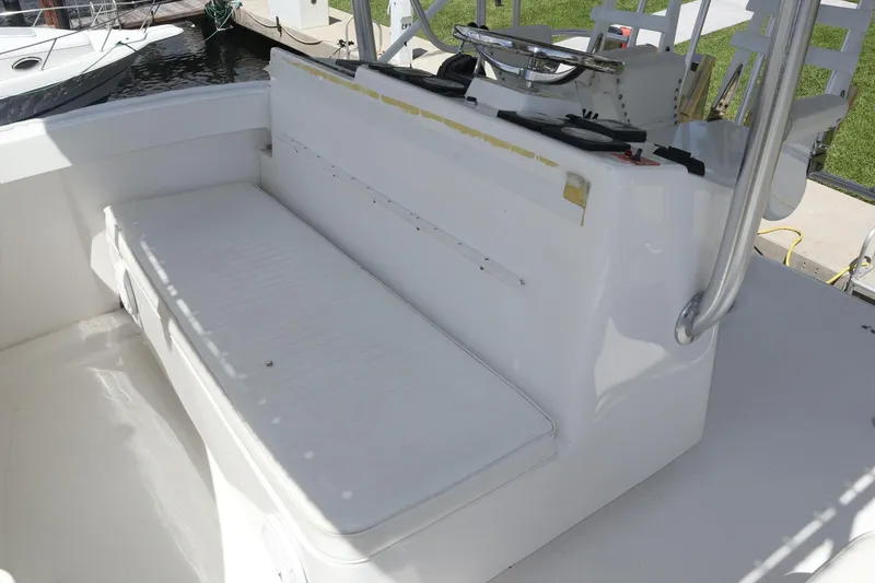 Slide: The Image of 2005 Luhrs 38 Convertible boat seating area with white cushioned bench. - 68
