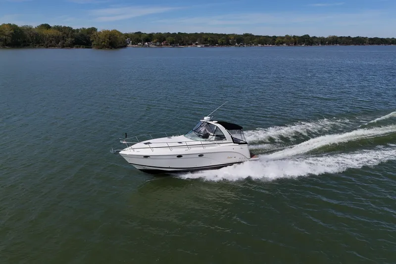 Slide: The Image of 2006 Rinker 360 Express Cruiser interior with kitchenette, microwave, sink, and cozy sleeping area. - 2