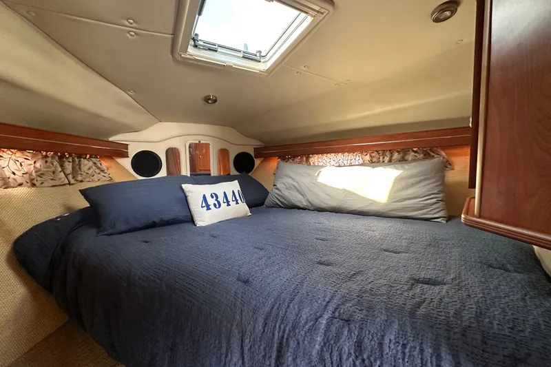 Slide: The Image of 2006 Rinker 360 Express Cruiser speeding on a calm lake under a clear sky. - 23