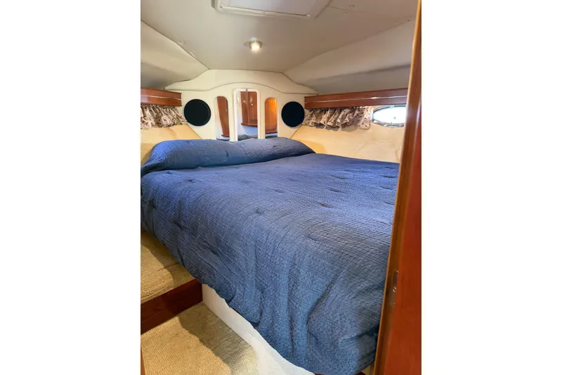 Slide: The Image of 2006 Rinker 360 Express Cruiser speeding on a serene lake under a clear blue sky. - 25