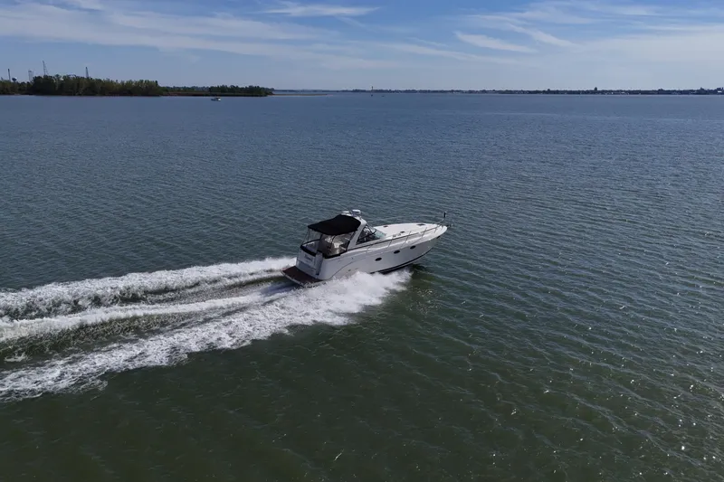 Slide: The Image of 2006 Rinker 360 Express Cruiser interior with cozy seating and wooden table. - 3