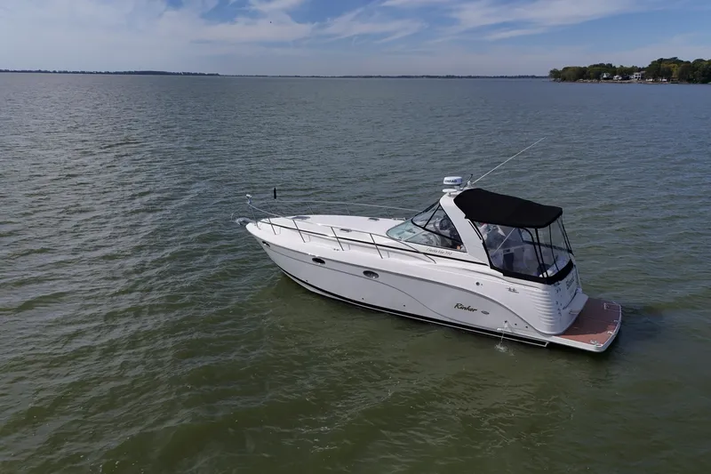 Slide: The Image of Interior cabin of 2006 Rinker 360 Express Cruiser with cozy bedding and ambient lighting. - 5