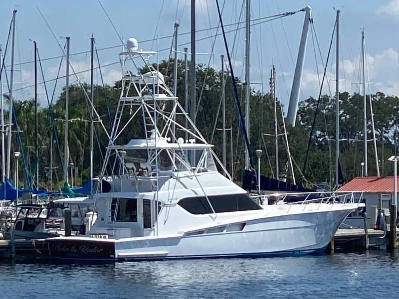 The Image of 2004 Hatteras 60 Convertible yacht docked at a marina with sailboats in the background. - 0