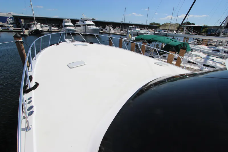 Slide: The Image of 2004 Hatteras 60 Convertible yacht deck in marina, surrounded by boats. - 10